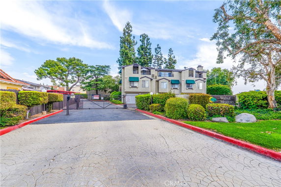 Front view of a gated residential building with multiple floors.