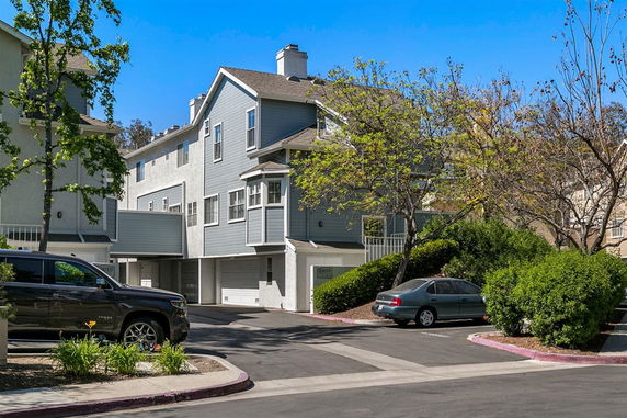 Front view of a multi-story house with an attached garage and a gabled roof.