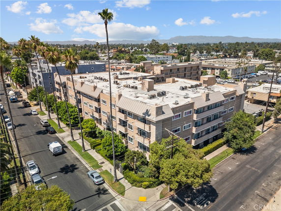 Aerial view of a multi-story residential building with a flat roof.