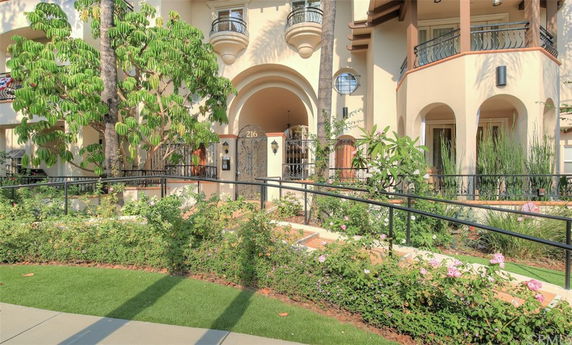 Front view of a multi-story building with balconies and arched entryways.