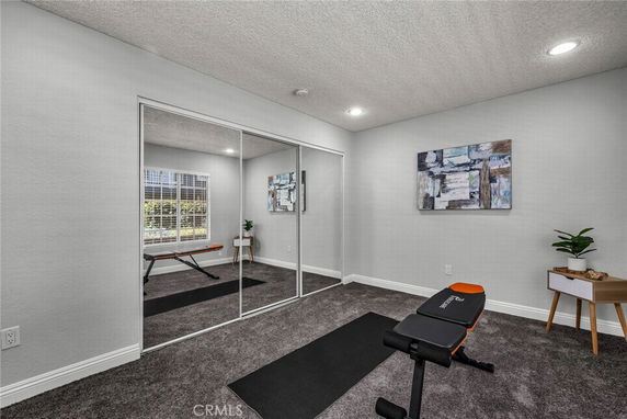 Room used as a home gym with bench and exercise mat.