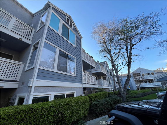 Front view of a multi-story residential building with large windows and balconies.