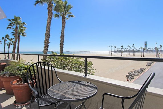 Panoramic view from a balcony overlooking a sandy beach and ocean.