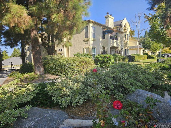Front view of a two-story house with a chimney and balconies.