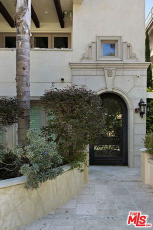 Front view of a building with arched doorway and ornamental details.