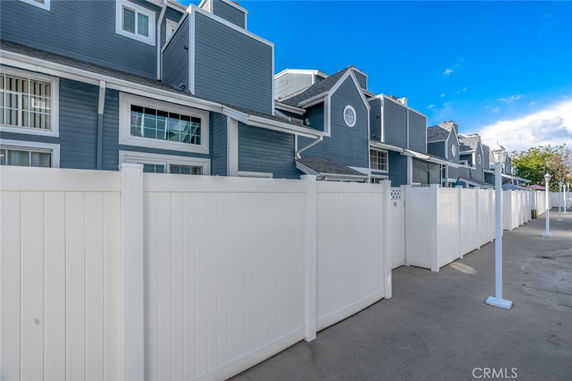Front view of a multi-story townhouse with blue siding and white trim.