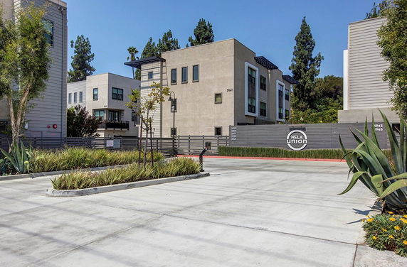Front view of a multi-story residential building complex with modern architecture.