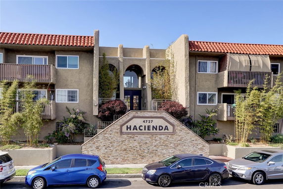Front view of a multi-story building with balconies and a stone sign reading 'Hacienda'.