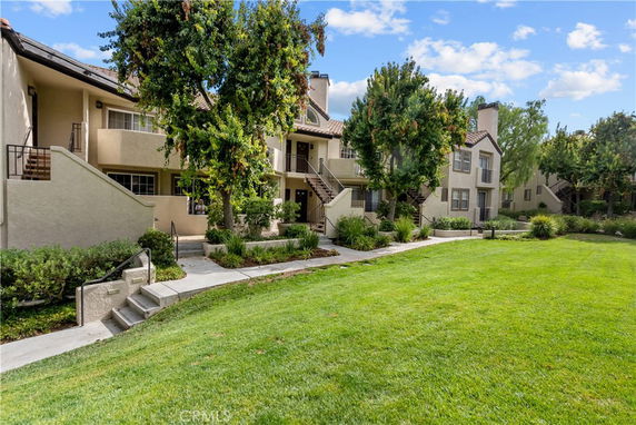 Front view of a multi-story residential building with balconies and landscaped areas.