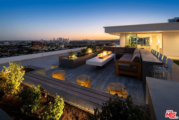 Rooftop with seating area, fire pit, and city skyline in the background