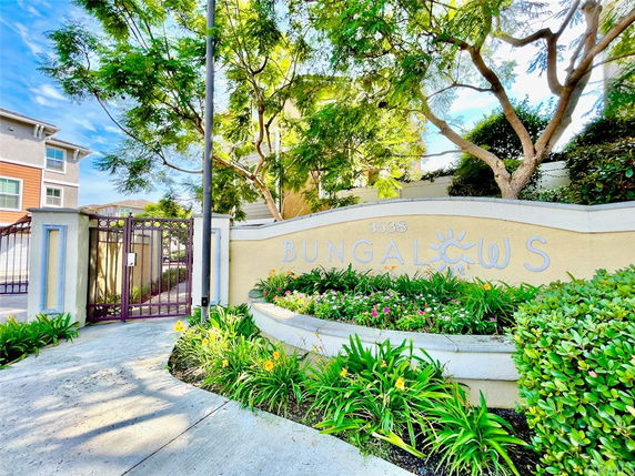 Entrance view of a residential complex with a gated entry and a sign reading 'Bungalows'.