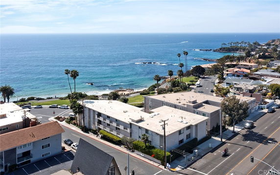 Aerial view of a coastal area with buildings and roads near the ocean.