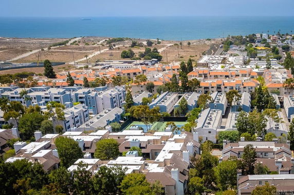 Panoramic view of residential buildings with a coastal backdrop.