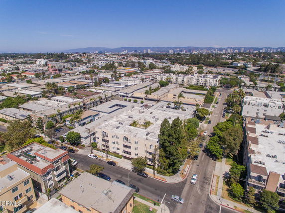 Aerial view of a residential area with multiple apartment buildings and cityscape in the distance.