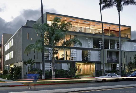 Front view of a modern multi-story building with various balconies and large windows.