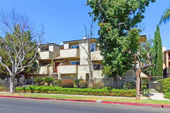 Front view of a multi-story residential apartment building with balconies.