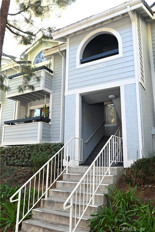 Front view of a multi-story building with an arched entrance.