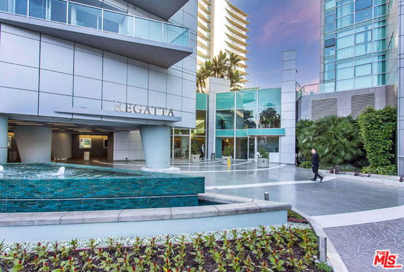 Front view of a modern building with a glass facade and water feature.