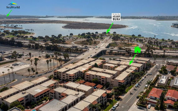Aerial view of a coastal area with buildings near a body of water and roads.