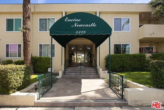 Front view of a building entrance with a green canopy labeled 'Encino Newcastle.'