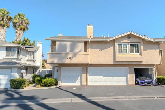 Front view of a two-story building with a garage and driveway.