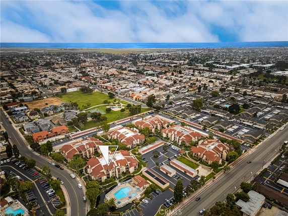 Panoramic view of a suburban neighborhood with multiple houses and a swimming pool.