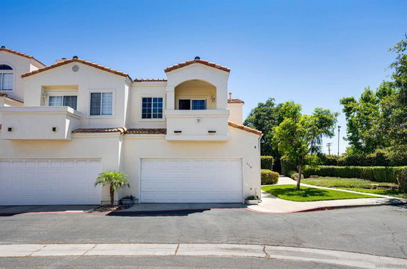 Front view of a two-story house with double garage and balcony.
