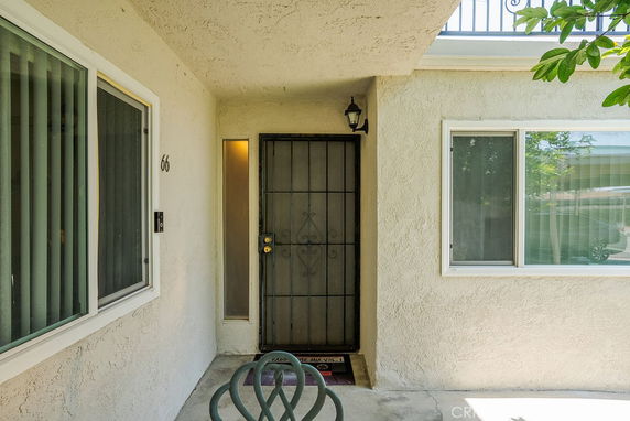 Front view of a house entrance with a metal security door and windows.