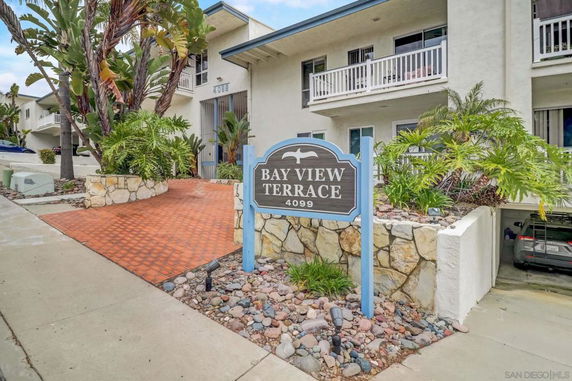 Front view of a multi-story building with a sign reading 'Bay View Terrace 4099' and surrounding greenery.