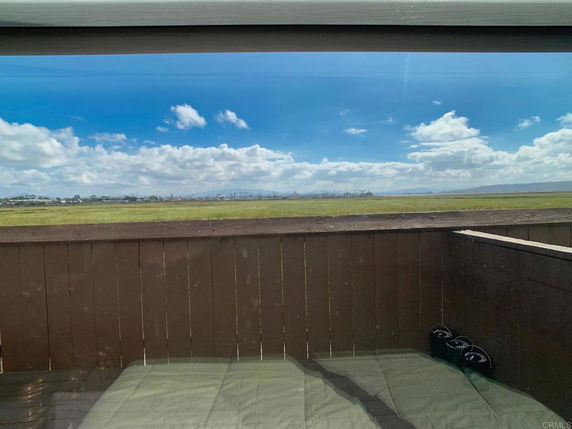 Wide angle view of a landscape with fields and distant trees seen from a building.
