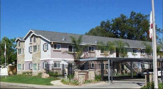 Front view of a two-story building with stone accents and gated entry.