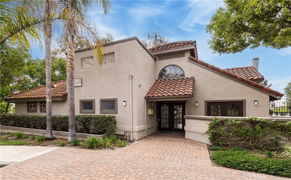 Front view of a house with a sloped roof and a paved walkway.