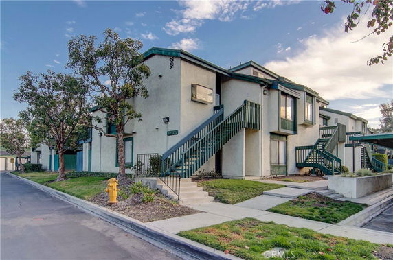 Front view of a two-story residential building with external staircases.