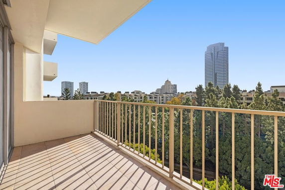 Balcony view of urban skyline with tall buildings and trees.
