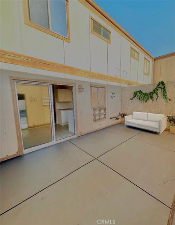 Exterior view of a two-story building with sliding glass doors and windows on the upper level.