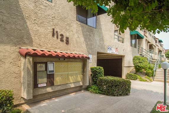 Front view of a building with mailboxes and a marked address.