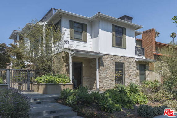 Front view of a two-story house with stone and white paneling.