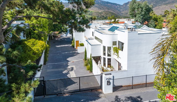 Front view of a modern two-story house with a gated entrance.