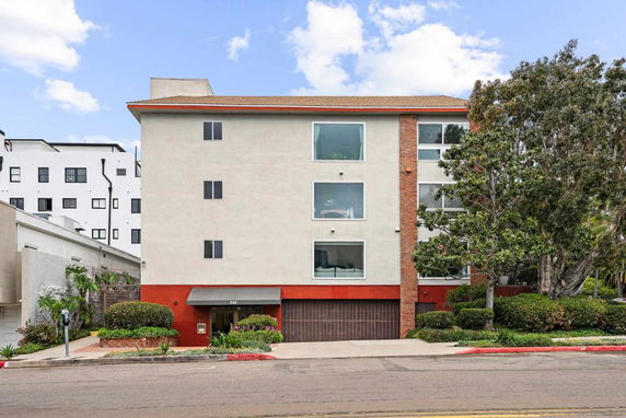 Front view of a multi-story building with a mix of beige and red exterior walls.