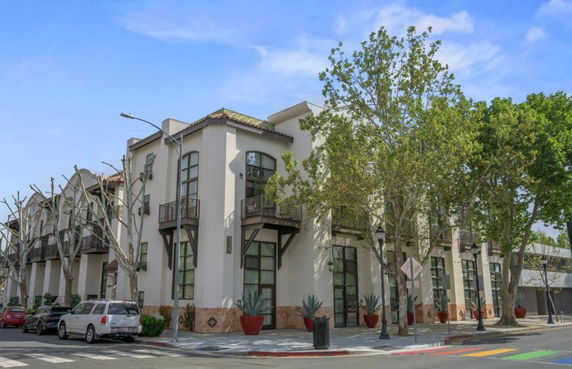 Front view of a multi-story building with large windows and balconies.