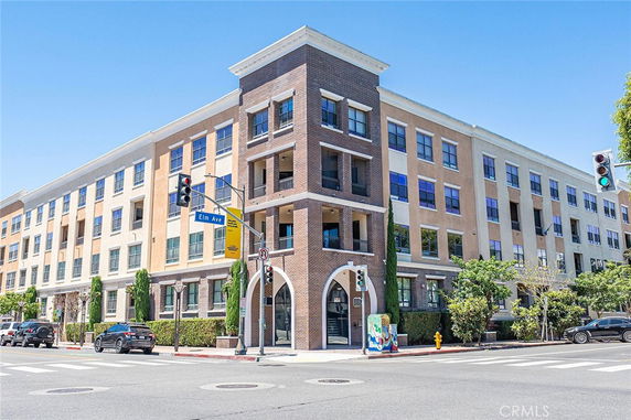 Front view of a four-story building on a street corner.
