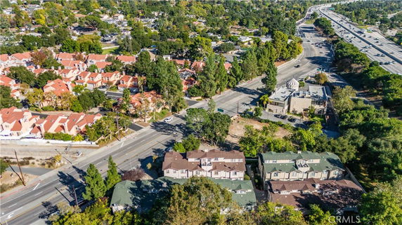 Panoramic aerial view of a residential area with highways and greenery surrounding the buildings.