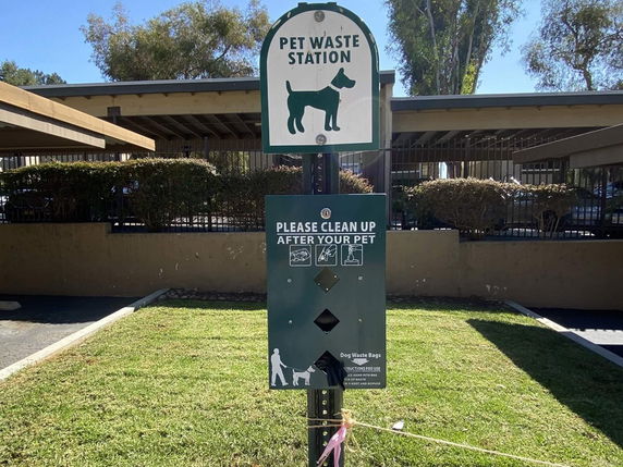 Pet waste station at an outdoor parking area.