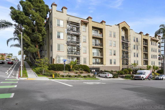 Front view of a multi-story apartment building with balconies.