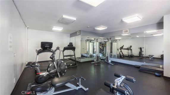 Indoor gym area with exercise equipment and mirrors.