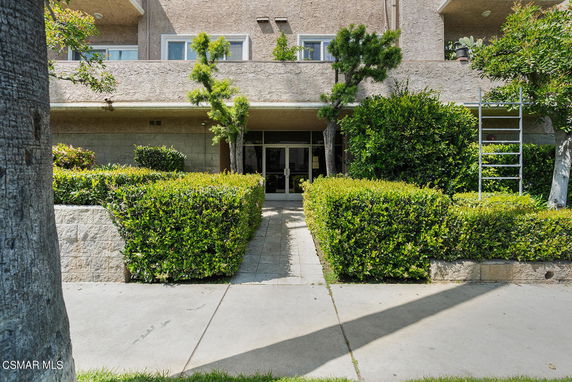 Front view of a multi-story building with landscaped entrance.