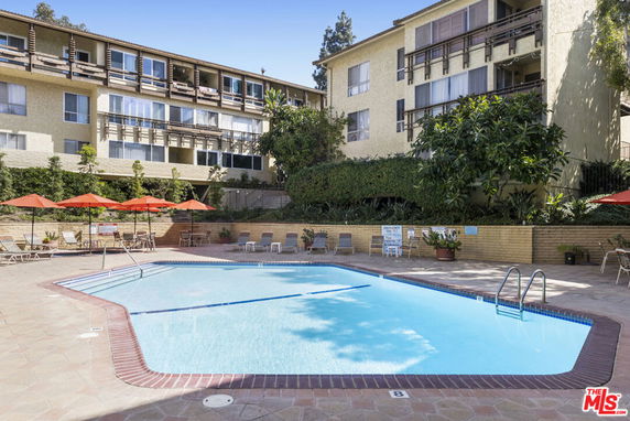 Swimming pool area in front of a multi-story residential building.