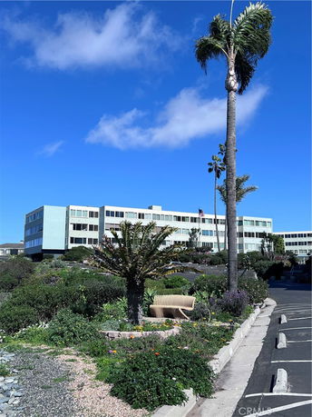 Front view of a multi-story building with large windows and landscaping.