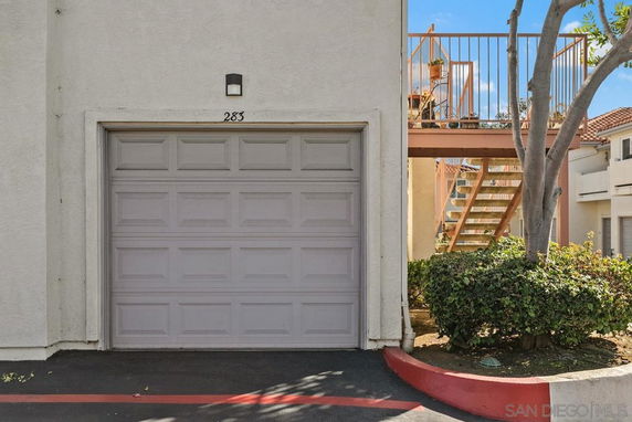 Front view of a building with a closed garage door and exterior staircase.