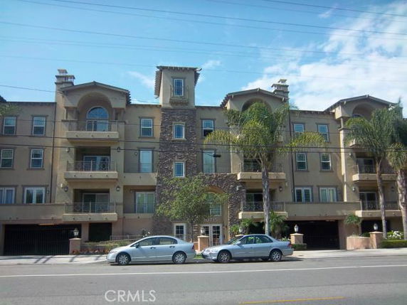 Front view of a multi-story building with balconies and arched windows.